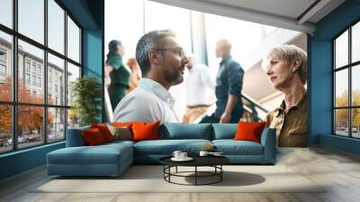 exchanging some business advice. shot of two businesspeople talking to each other while standing on  Wall mural