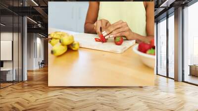 Woman, hands and cutting strawberry in kitchen for diet, healthy meal or fruit salad at home. Closeup of female person or vegetarian slicing organic red fruits for natural nutrition, vitamin or fiber Wall mural