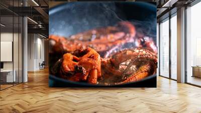 Cooking tentacles of octopus in frying pan. Wall mural