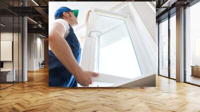 Professional handyman installing window at home. Wall mural