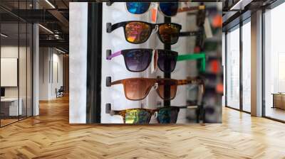 Rotatable rack with colorful sunglasses in market. Wall mural