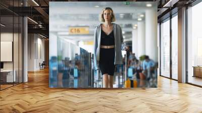 Tween girl with suitcase walking in airport terminal. Wall mural