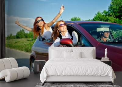 Two pretty happy girls in the car. Concept of carefree roadtrip Wall mural