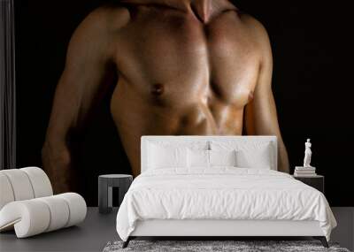 Unrecognizable muscular male body on black background. Wall mural