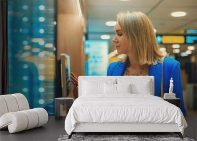 Woman pays at self-checkouts in supermarket. Wall mural