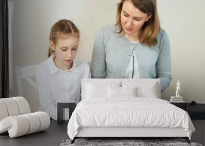 Woman teaching little girl to play the piano. Wall mural