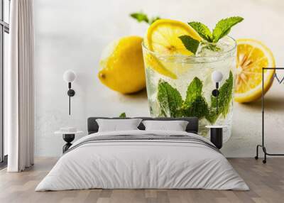 Refreshing lemonade drink garnished with fresh mint leaves and lemon slices on a light background Wall mural