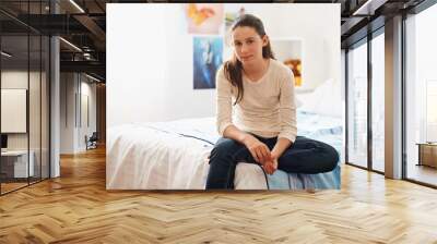 A day in the life of a teen. Portrait of a teenage girl sitting on her bed at home. Wall mural