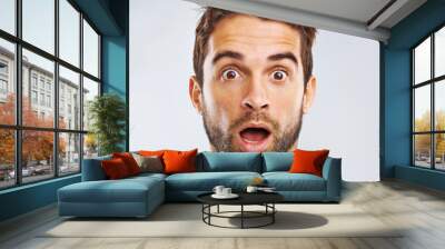 What just happened. Portrait of a shocked young man against a gray background. Wall mural