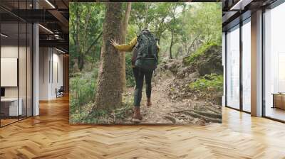 Asian young woman hiking and backpack wearing yellow sweater and boots walking in the forest Wall mural