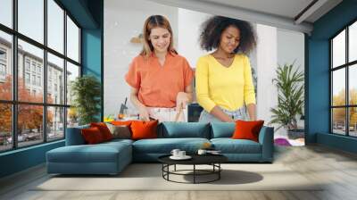 Happy lesbian couple women enjoy cooking together in kitchen room at home. Two woman spending cooking time together in weekend at kitchen room. Lgbt relationship concept Wall mural