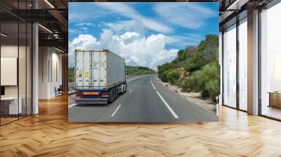 Truck transporting a container circulating on the highway. Wall mural