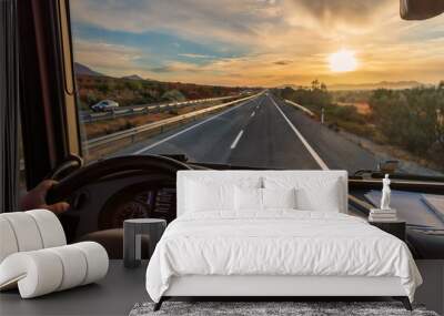 View from the driver's seat of a truck of the highway and a landscape of fields at dawn, with a dramatic sky. Wall mural