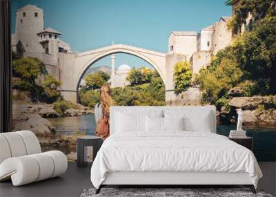 Female tourist looking at famous old bridge and river of Mostar- tour tourism,travel,vacation in Bosnia Wall mural