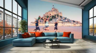 Happy family jumping in front of Mont Saint Michel-  vacation, travel destination, tour tourism concept Wall mural