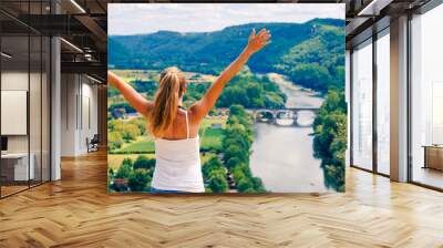 Happy woman with open arms enjoying panoramic view of Dordogne landscape and river- France Wall mural