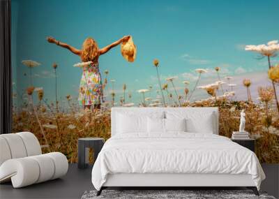 Pretty woman with colorful dress and hat in a flowers field- happiness,  freedom,  carefree, active or health concept Wall mural