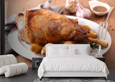 roasted lamb leg with potato and sauce on wood background Wall mural