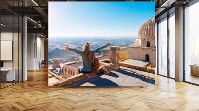 Traveler woman in Turkey,  female tourist sitting on rooftop enjoying panoramic view of Mardin city Wall mural