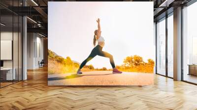 young woman doing yoga in nature on sunrise road- sport,flexibility,active lifestyle,stretching concept Wall mural