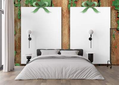 Close-up of two blank frames hanged by green ribbons against old scratched wooden boards background Wall mural