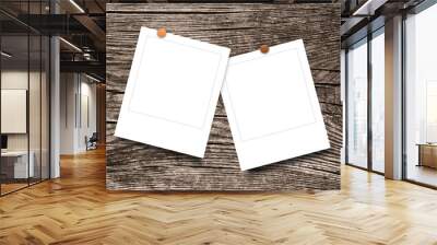 Close-up of two hanged square photo frames with pins on brown wooden background Wall mural