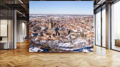 Medieval Hanseatic Dutch tower town Zutphen in the Netherlands covered in snow with historic heritage buildings and river IJssel passing by in the background Wall mural