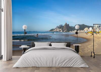 Panorama of early morning Ipanema beach in Rio de Janeiro with the ocean and footsteps on the beach in the foreground and the Two Brothers mountain in the background against a clear blue sky Wall mural