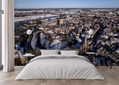 Picturesque winter wonderland aerial of medieval Hanseatic Dutch tower town Zutphen in the Netherlands covered in snow with historic heritage buildings and river IJssel passing by in the background Wall mural