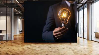 Businessman holding light bulb with AI concept glowing on dark background Wall mural