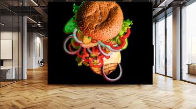 Flying ingredients for a homemade Burger on a dark background. Isolated on a black background. Vegetables and meat. The bun for the Burger. Wall mural