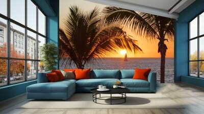 Beautiful tropical orange sunset with palm trees and sail boat Wall mural