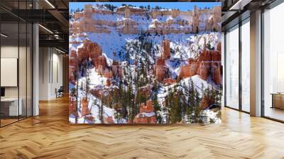 A breathtaking winter view of the hoodoos in Bryce Canyon National Park. Showcasing the unique rock formations dusted with snow under a clear blue sky. Captured in a majestic landscape - Utah, USA Wall mural