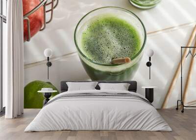 A glass of green juice with paper straws in the background Wall mural