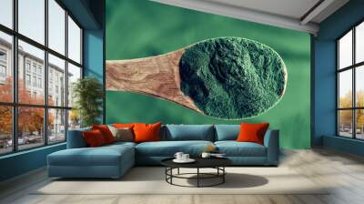 A spoonful of spirulina algae powder over a spirulina background, top view Wall mural