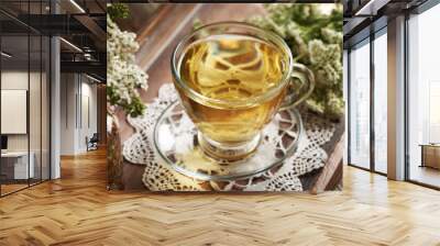 Herbal tea in a transparent glass cup with fresh yarrow or Achillea millefolium flowers Wall mural