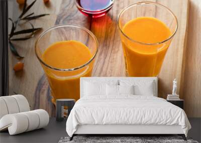 Two glasses of sea buckthorn juice, with sea buckthorn oil and berries Wall mural