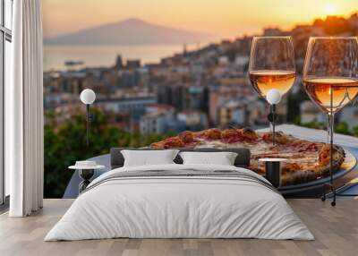 Whole pizza margherita on a restaurant table with two glasses of rose wine, with a panorama of Naples, Italy Wall mural