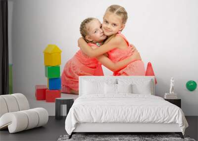 Happy two girls embrace building a castle out of blocks Wall mural