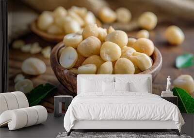 Raw peeled macadamia nuts in wooden bowl on rustic wooden background Wall mural