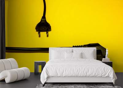 Two types of black unplugged electric plugs on yellow background Wall mural