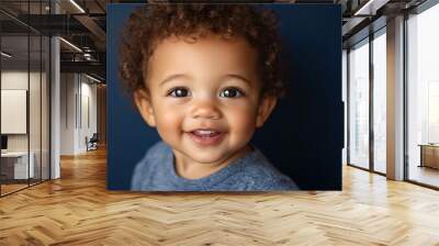 Biracial baby boy with light brown skin and curly hair, smiling on a dark blue background 2 Wall mural