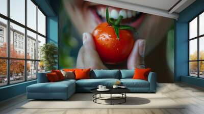 Close-up of someone enjoying a bite of a juicy, ripe tomato Wall mural