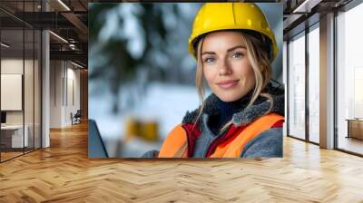 Portrait of a female solar panel technician in safety gear using a laptop to monitor and analyze the power output of the solar panels on a renewable energy installation Wall mural