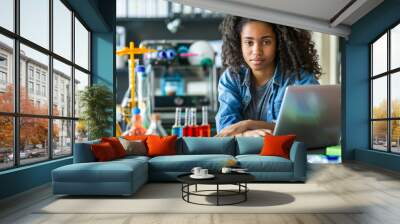 Focused female student using laptop in science laboratory Wall mural