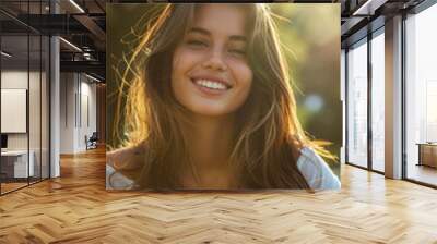 Smiling young woman with natural beauty enjoying sunlight in a serene outdoor setting Wall mural