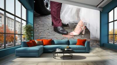 Feet in shoes of the bride and groom on the old cobblestones. Wedding clothing newly married. Wall mural