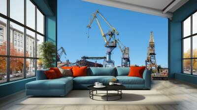 Loading cranes at the sea port. Cargo transportation by ships. Wall mural