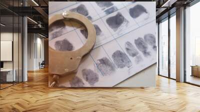 Close up of police handcuff on criminal fingerprint crime page file. Wall mural