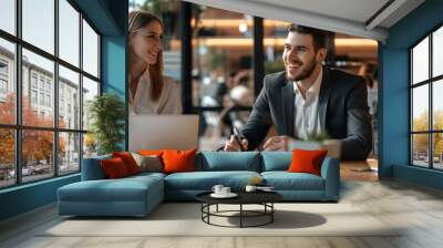 Young male and female businessmen are discussing business in a coffee shop Wall mural